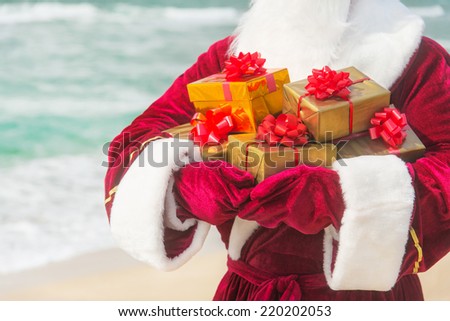 Santa Claus close up with many golden gifts on sea beach - christmas or happy new year concept