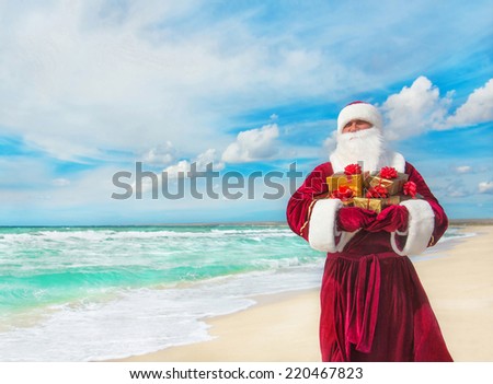 Santa Claus with many golden gifts on sea beach - christmas or happy new year concept