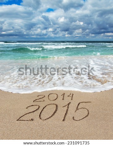 Happy New Year 2015 wash away year 2014 concept on sea sand beach Happy New Year 2015 wash away year 2014 concept on sea sand beach