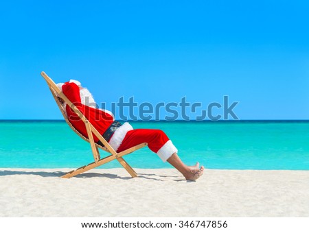 Santa Claus resting on wooden sun bed at ocean sandy tropical beach - New Year and Christmas travel vacation in hot countries concept
