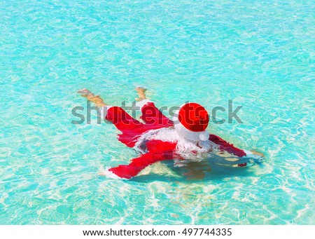 Santa Claus relax swimming in ocean turquoise azure transparent water, Christmas and New Year holidays travel destinations in hot countries concept