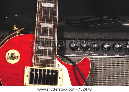 Classic electric guitar leaning on amplifier. Tuner on top of amp.