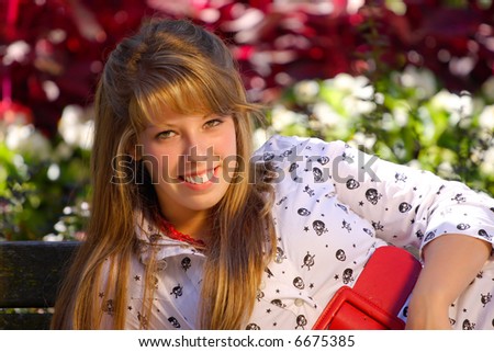 A teenage girl lying down on a bench, Smiling big,