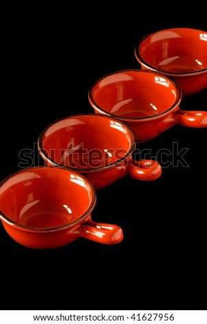 four red Gravy boat on a black background