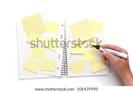 hand writing on sticky notes in exercise book