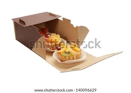 sweet cake with fruits in box isolated on white
