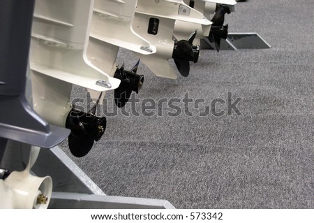 At a boat show outboard motors are lined up in a row