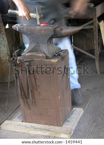 Blacksmith forges link on anvil