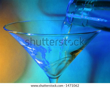 Pouring a drink into a martini glass. Focus in plane of pour which is motion blurred (compare left and right side of rim)