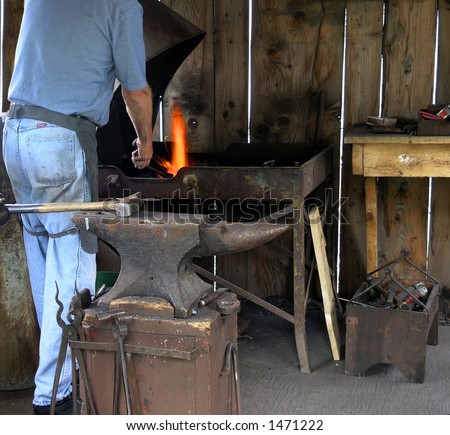Blacksmith heating iron in a forge.