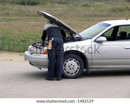 Mechanic checks out car under hood.
