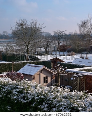 First snow in Belgium. View on little house in a belgian garden.
