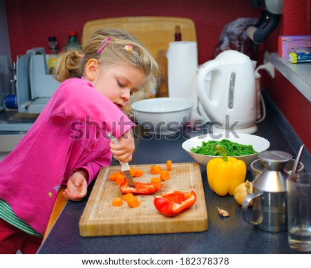 little girl is working in the kitchen