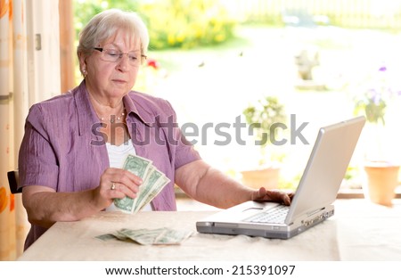 older woman with money and computer