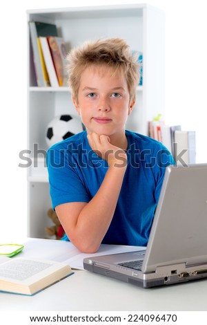 boy is doing homework with book and computer