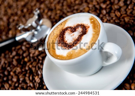 cappuccino with heart on a lot of coffee beans