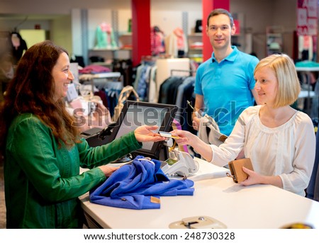 young woman and man in the clothes shop over the counter