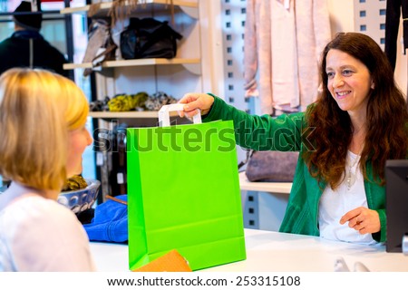 young woman in the clothes shop over the counter