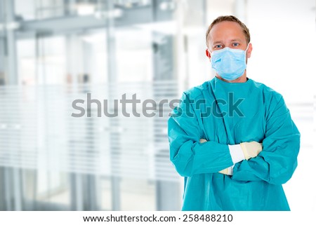young doctor with surgical mask and green coat