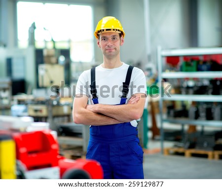 worker in work clothes with yellow helmet in factory