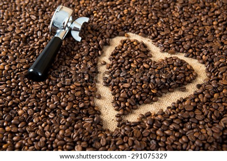 heart in a lot of coffee beans with heart with portafilter
