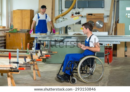 disabled worker in wheelchair in a carpenter\'s workshop