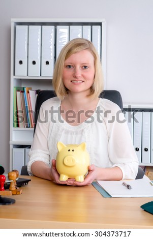 young business woman with piggy bank in the office