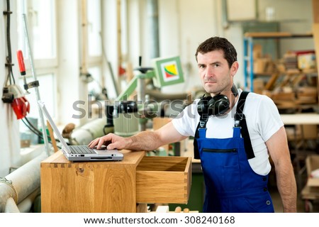 worker in a carpenter\'s workshop using computer