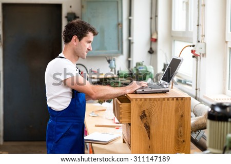 worker in a carpenter\'s workshop using computer