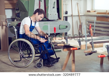 disabled worker in wheelchair in a carpenter's workshop
