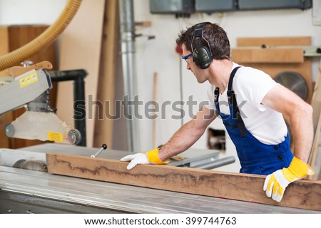 worker in a carpenter\'s workshop using saw machine