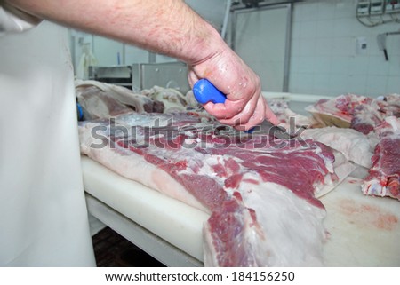 The butcher cuts fresh bacon