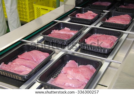 Packing of meat slices in boxes on a conveyor belt