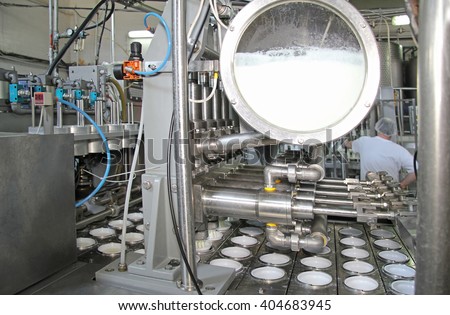 Production of yogurt in a dairy factory, industrial equipment for filling in plastic cups