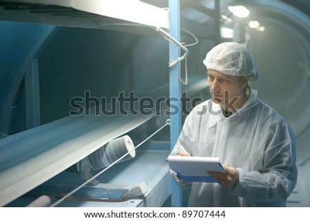 Worker controls sugar on production line in a factory