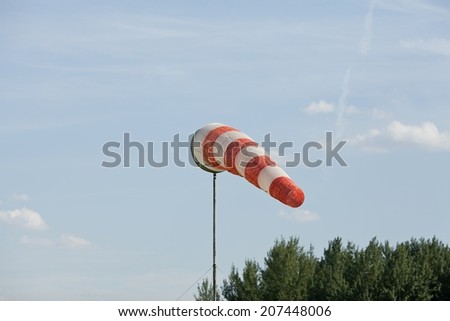 Air field direction sign and a wind force (windsock) against the dark blue sky
