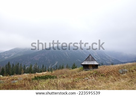 Scenic landscape in the Tatra Mountains in Poland, simple wooden cabins on the meadow