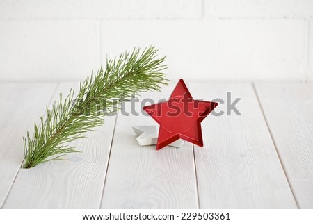 Closeup of Christmas interior decoration in simple, minimalist, elegant style with pine branch on white wood floor and wall background. Plenty of copy space.