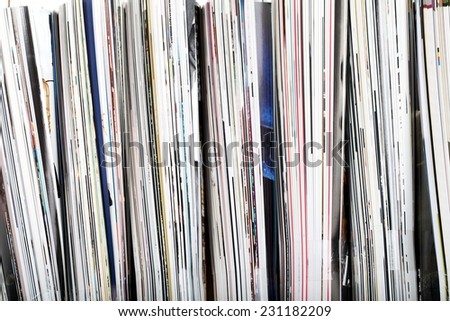 Magazine and newspaper. Close up stack of magazines on white wood background