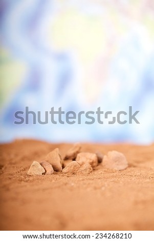 Close up red desert sand with wold map background.