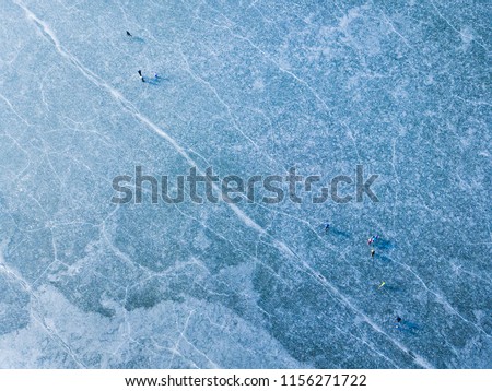 Aerial view of frozen lake. Many ice skaters on the ice. Winter background concept. Dam Ceske Udoli near Pilsen, Czech republic, European union.