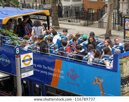 LONDON, UK - JULY 19: Students on open sightseeing tour bus on July 19, 2012, London, UK. London attracts over 14 million international visitors per year, making it Europe\'s most visited city.