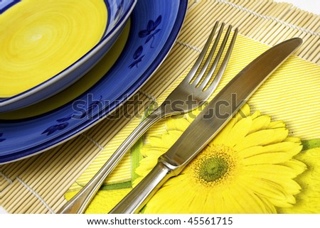 domestic place setting with handmade plates and napkin, knife, fork