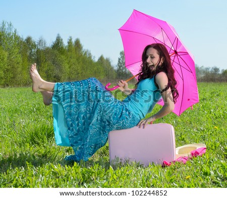Young smiling woman   falls down on grass outdoor in summer