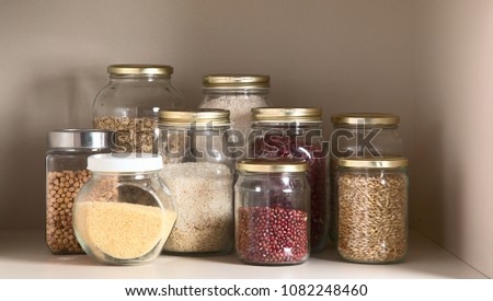 Collection of grain products in storage jars in pantry