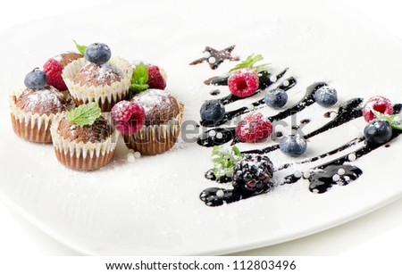 Cupcakes  and sweet  christmas tree with berries  isolated on white