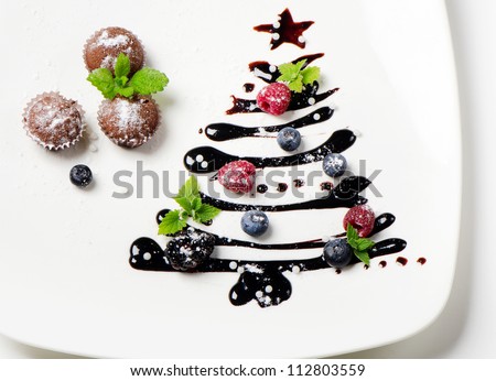 Cupcakes  and sweet  christmas tree with berries and mint