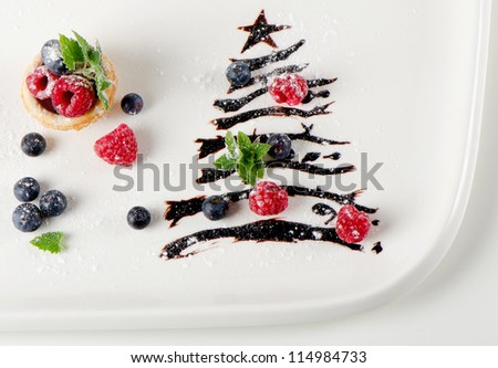 sweet christmas tree with berries and mint on a white plate