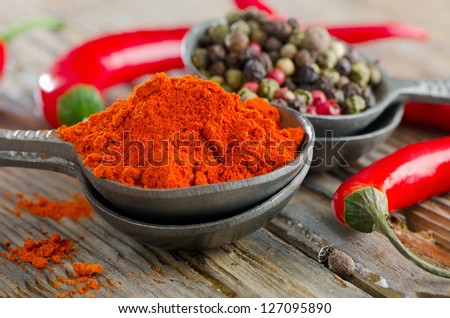 Black pepper and red  pepper on a wooden table. Selective focus