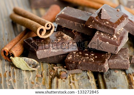 Broken Chocolate Bar And Spices On Wooden Table. Selective Focus
